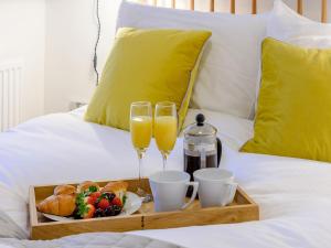 two glasses of champagne and a tray of food on a bed at The Nook - Uk36720 in Glaisdale
