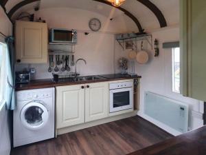 a kitchen with a washing machine and a washer at Elsie in Blue Anchor