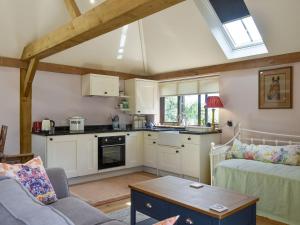 een keuken met een bank en een tafel in een kamer bij The Granary in West Hoathley