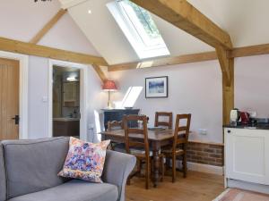een keuken en een woonkamer met een tafel en stoelen bij The Granary in West Hoathley