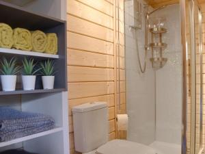 a bathroom with a toilet and shelves with plants at Poppy Lodge in Minster