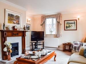 a living room with a fireplace and a tv at The Old Exchange in Market Bosworth