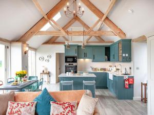 uma cozinha com armários verdes e uma sala de estar em Old Farm em Barton Saint David