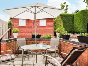 a patio with a table and chairs and an umbrella at The Old Exchange in Market Bosworth