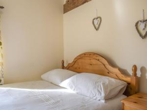 a bedroom with a bed with a wooden headboard at Border View in Kington