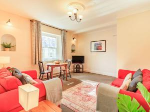 a living room with a red couch and a table at Dunster Castle Hill View - Uk13179 in Dunster