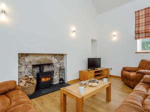 a living room with a couch and a fireplace at Auld Kirk Hall in Kirktown of Auchterless