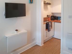 a kitchen with a flat screen tv on a wall at Osocozee in Millport