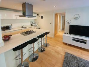 a kitchen with a stove and a counter top at Apartment 4, Zinc in Newquay