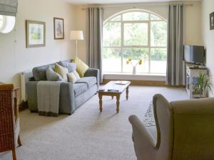 a living room with a couch and a table at Lapwing Cottage in Longframlington