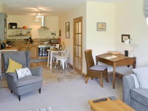 a living room with a couch and a table at Lapwing Cottage in Longframlington