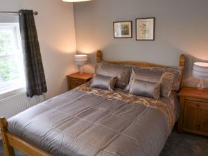 a bedroom with a bed with two lamps and a window at Church Farm House in Sea Palling