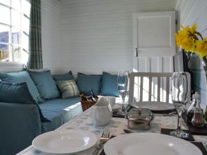 a living room with a blue couch and a table at Field House Lodge in Borrowdale