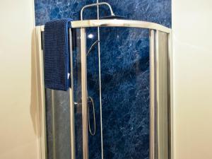 a shower in a bathroom with a blue wall at Sheep One - Uk33361 in Threlkeld