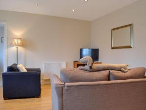 una sala de estar con un sofá con un animal de peluche. en Croft Cottage 1 - Uk10587, en Stillington