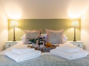 a bedroom with a bed with a basket of towels at Church Cottage in Thurlton