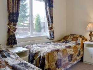 a bedroom with a bed and a window at Lodge C- Uk33089 in Dinnet