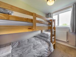 a bedroom with two bunk beds and a window at Meadowcroft in Bettws Disserth