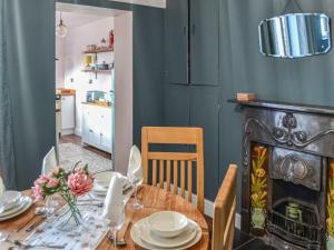 a dining room with a table and a fireplace at Broads Rest in Martham
