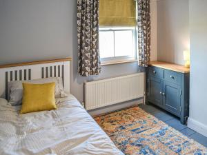 a bedroom with a bed and a window at Broads Rest in Martham