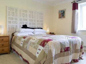 a bedroom with a bed with a quilt on it at Elizabeth House in Bampton