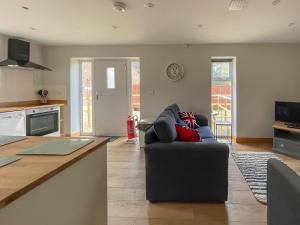 a living room with a couch and a kitchen at The Firs - Uk33999 in Child Okeford