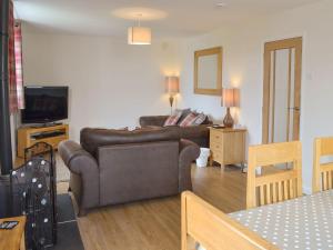 a living room with a couch and a television at The Old Parish Hall in Seahouses