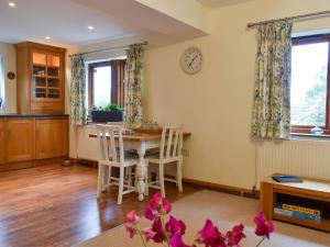 a dining room with a table and chairs and a clock at Quarry Cottage in Highpeak Junction