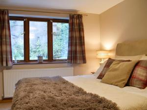 a bedroom with a bed and a window at Quarry Cottage in Highpeak Junction