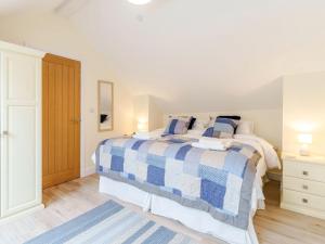 a white bedroom with a blue and white bed at Ty Arth - Uk31652 in New Quay