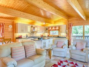 a living room with white couches and a kitchen at Cherry Lodge- Uk37608 in Legbourne