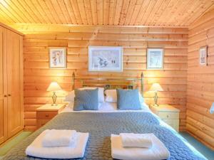 a bedroom with a bed in a wooden wall at Cherry Lodge- Uk37608 in Legbourne