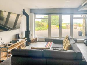 a living room with a couch and a stove at Stable View, Ambron House in Barlow