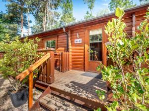 a cabin with a wooden deck in the woods at Cherry Lodge- Uk37608 in Legbourne