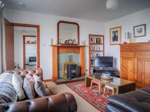 sala de estar con sofá y chimenea en The Nicolson House, en Graver