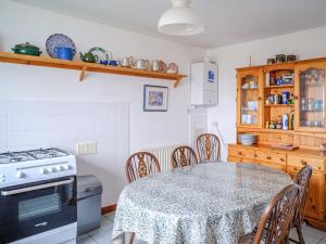 a kitchen with a table with chairs and a stove at The Nicolson House in Graver