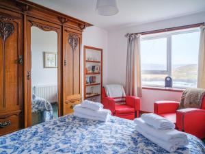 a bedroom with a bed and chairs and a window at The Nicolson House in Graver