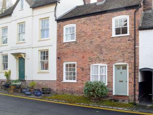 a red brick house with white windows at The Cottage in Ledbury