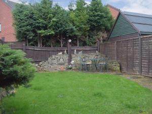 a backyard with a fence and a table and chairs at Withybrook Cottage in Hereford