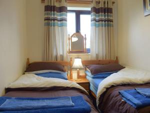 two twin beds in a room with a window at Withybrook Cottage in Hereford