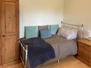 1 cama con almohadas en el dormitorio en Honeypot Cottage en Maresfield