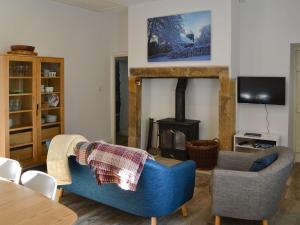 a living room with a blue couch and a fireplace at Horsley Cottage in Rochester