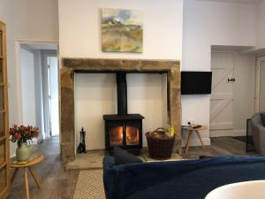 a living room with a fireplace and a blue couch at Horsley Cottage in Rochester