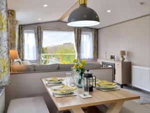 cocina y sala de estar con mesa de madera en Kipp Away, en Kippford