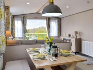 a kitchen and living room with a wooden table at Kipp Away in Kippford