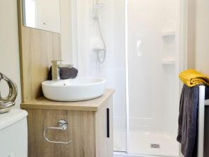 uma casa de banho com um lavatório branco e um chuveiro em Kipp Away em Kippford