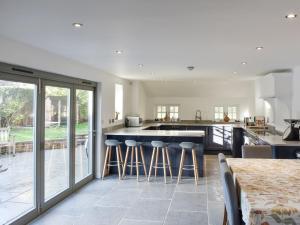 a kitchen with a counter and bar with stools at Oasis in Bradwell on Sea