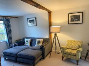 um quarto com uma cama azul e uma cadeira em Oasis em Bradwell on Sea