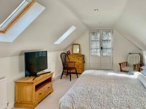 um quarto com uma cama e uma televisão de ecrã plano em Oasis em Bradwell on Sea
