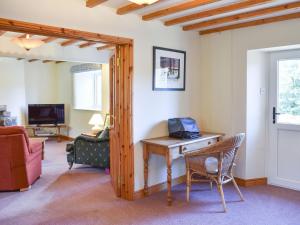 a room with a desk with a laptop on it at Southwaite in Outhgill